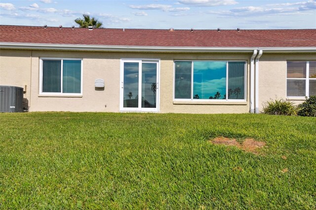 back of house with a yard and central AC