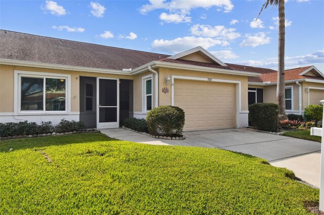 single story home with a garage and a front lawn