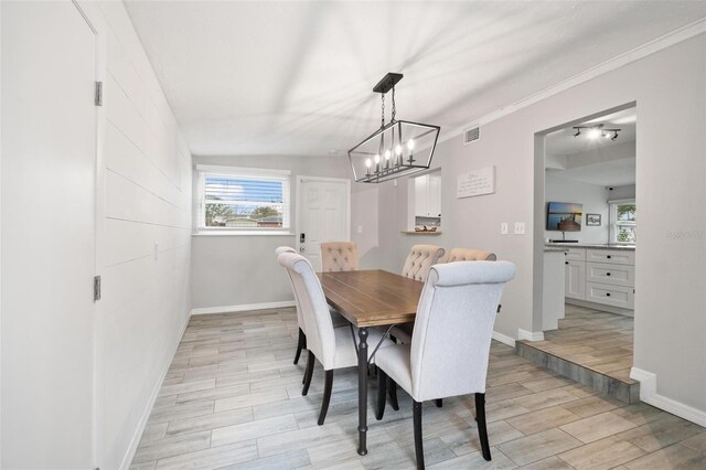 dining space featuring a wealth of natural light, a chandelier, and ornamental molding