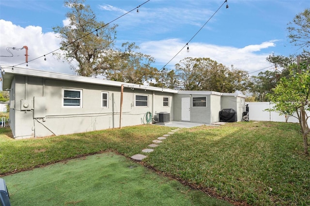 rear view of property with a yard and cooling unit