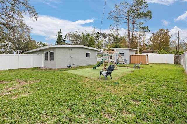 view of yard with a playground and a storage unit