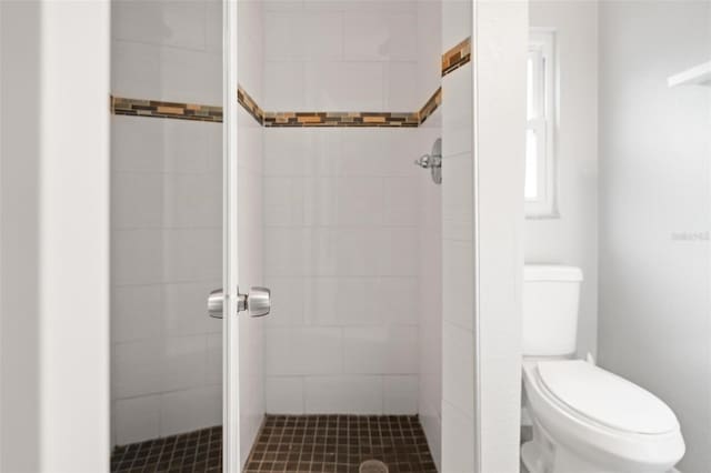 bathroom with tiled shower and toilet