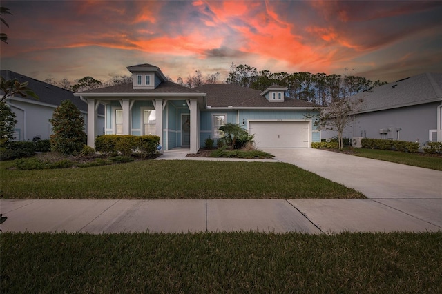 view of front of home with a garage and a lawn