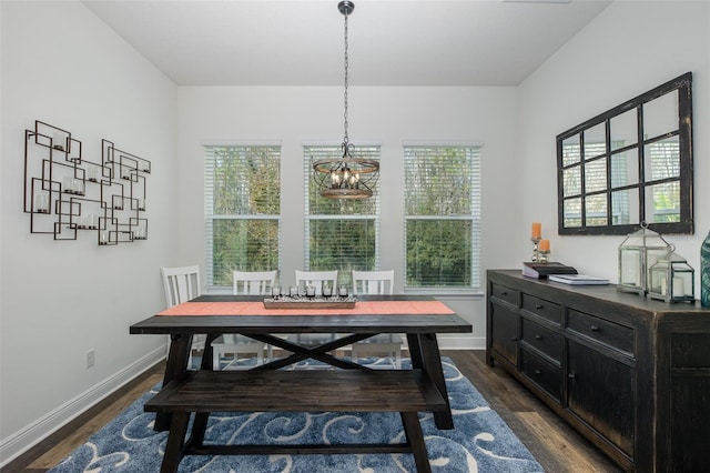 dining space with dark hardwood / wood-style floors, a wealth of natural light, and a chandelier