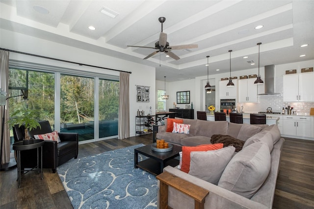 living room featuring ceiling fan, beam ceiling, and dark hardwood / wood-style flooring