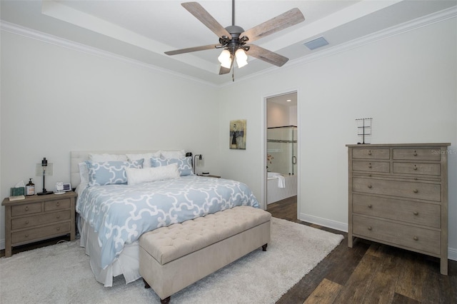 bedroom with connected bathroom, ceiling fan, a raised ceiling, dark hardwood / wood-style floors, and crown molding