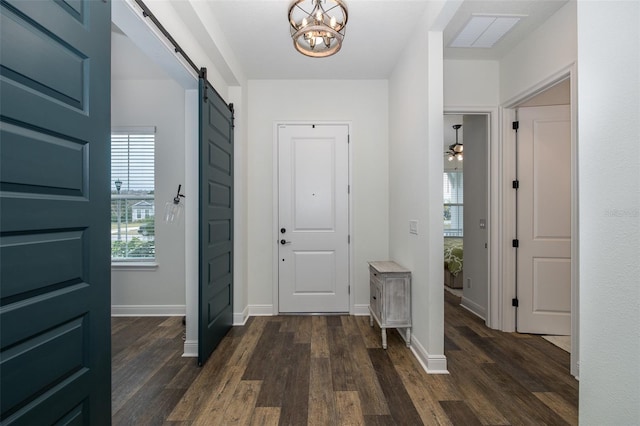 entrance foyer featuring a barn door, dark hardwood / wood-style floors, and an inviting chandelier