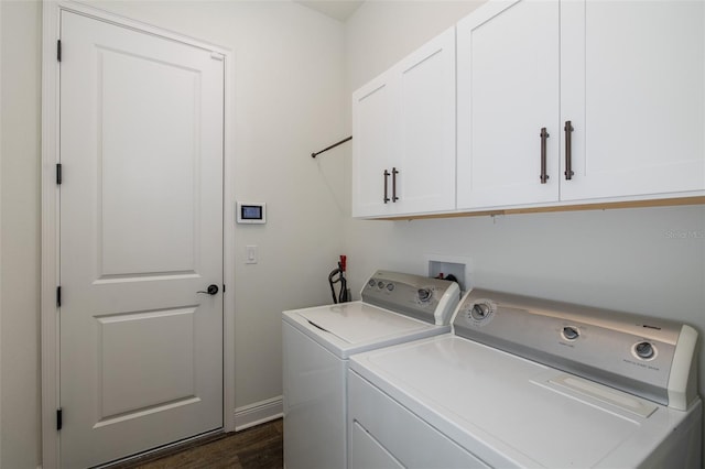 laundry room with cabinets, dark hardwood / wood-style floors, and washing machine and clothes dryer