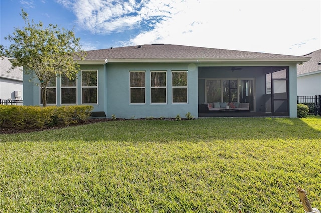 back of house featuring a lawn and a sunroom