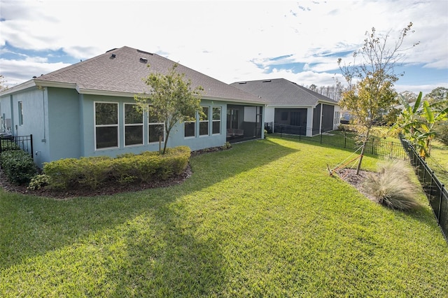 back of property with a lawn and a sunroom