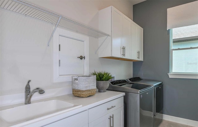 laundry room featuring cabinets, washer and clothes dryer, and sink