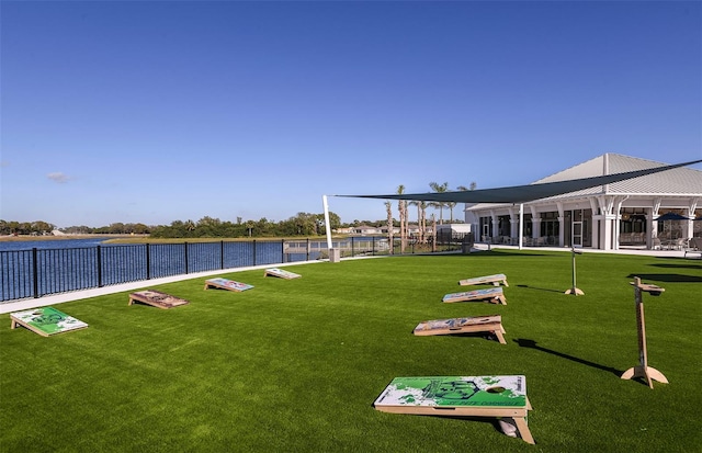 surrounding community with a water view and a lawn