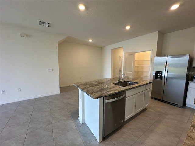 kitchen featuring white cabinets, appliances with stainless steel finishes, a center island with sink, and sink