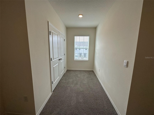 hall featuring carpet floors and a textured ceiling