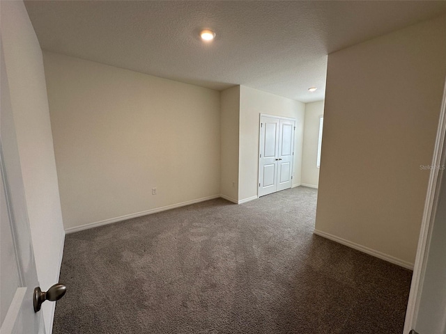 carpeted empty room with a textured ceiling