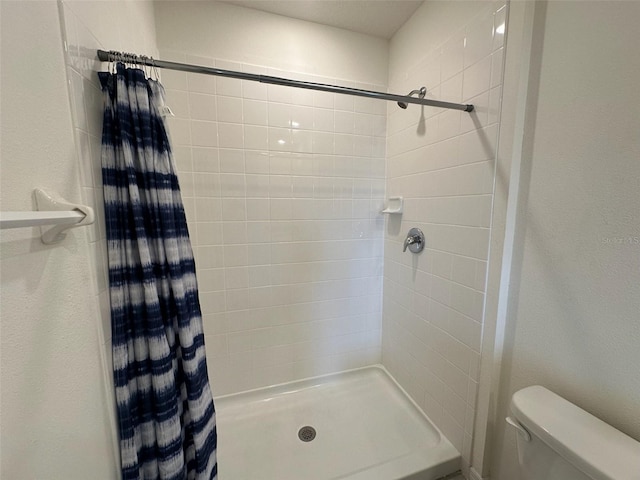 bathroom featuring a shower with curtain and toilet