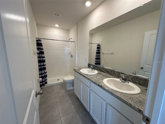 bathroom with a shower with shower curtain, tile patterned floors, vanity, and toilet