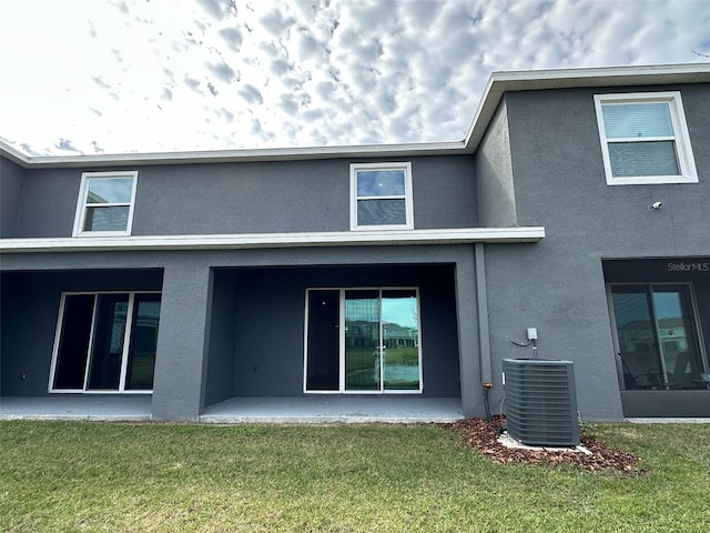 back of house featuring a patio area, a yard, and central AC