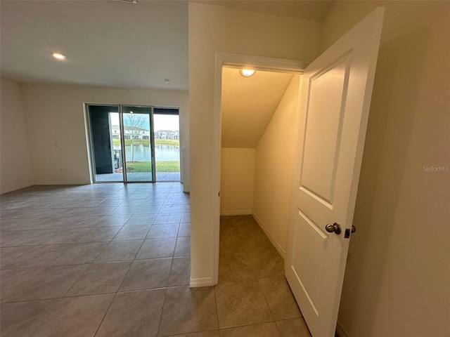 interior space featuring light tile patterned flooring and a water view