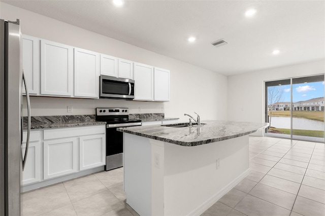 kitchen featuring a water view, stainless steel appliances, sink, and white cabinets