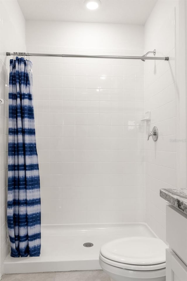 bathroom with toilet and a shower with shower curtain