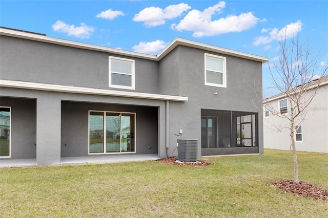 rear view of property featuring cooling unit, a yard, a patio area, and a sunroom