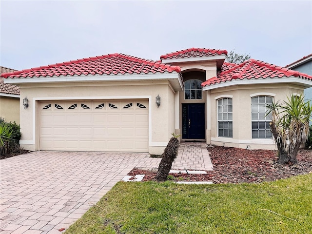 mediterranean / spanish house with a front lawn and a garage