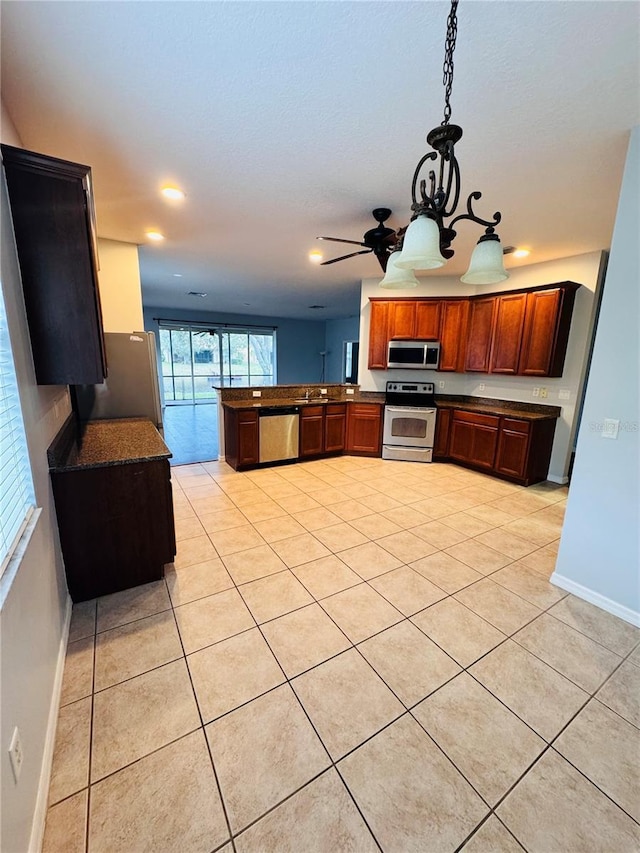 kitchen featuring ceiling fan with notable chandelier, decorative light fixtures, light tile patterned flooring, kitchen peninsula, and stainless steel appliances