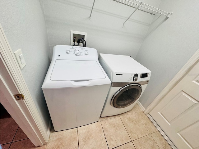 laundry area featuring washing machine and dryer and light tile patterned floors