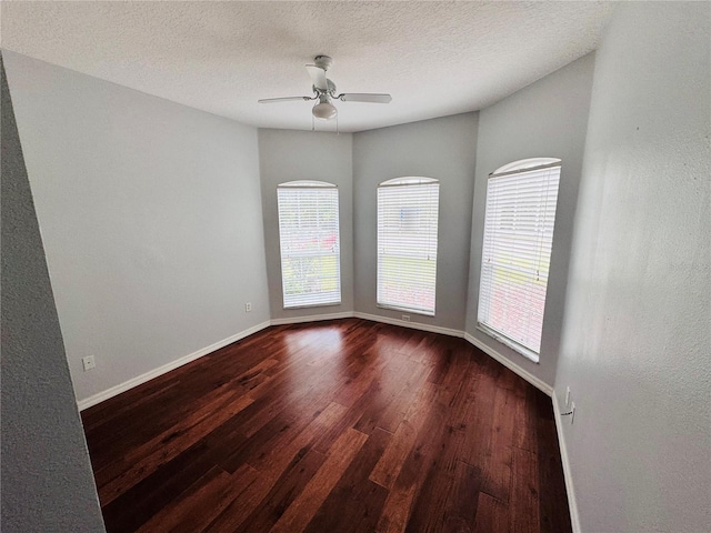 unfurnished room featuring ceiling fan, dark wood-type flooring, and a textured ceiling