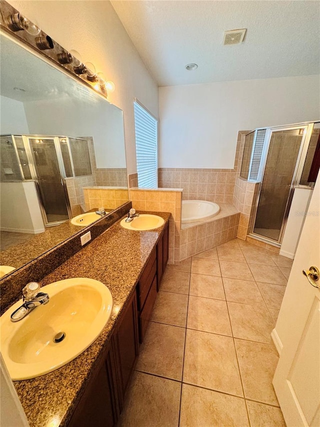 bathroom featuring plus walk in shower, vanity, and tile patterned floors