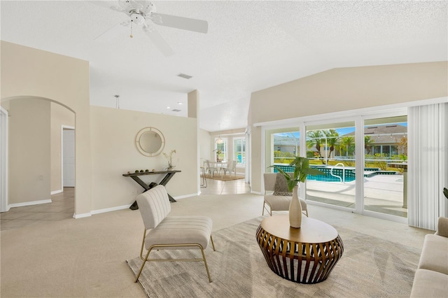 sitting room featuring a textured ceiling, ceiling fan, light colored carpet, and vaulted ceiling