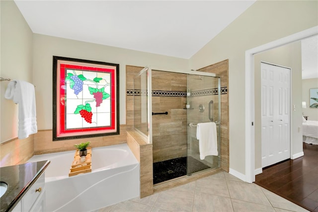 bathroom featuring tile patterned flooring, vanity, plus walk in shower, and lofted ceiling