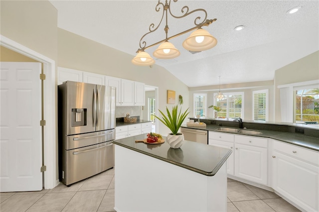 kitchen featuring white cabinets, appliances with stainless steel finishes, lofted ceiling, and sink