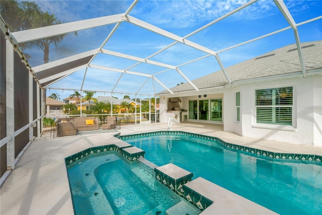 view of pool with an in ground hot tub, glass enclosure, and a patio area