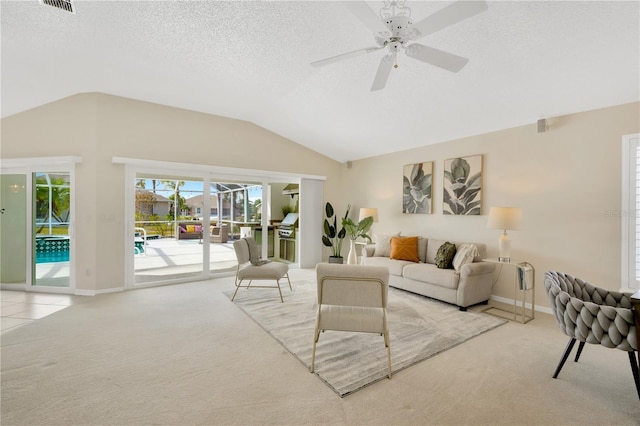 living room featuring vaulted ceiling, ceiling fan, light colored carpet, and a textured ceiling