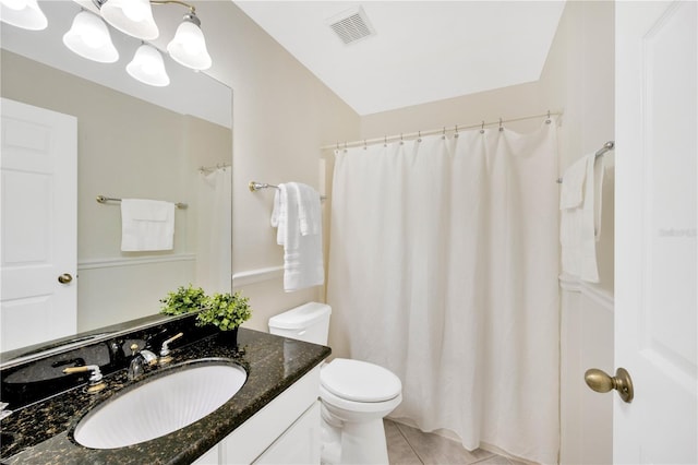 bathroom with tile patterned flooring, vanity, toilet, and vaulted ceiling