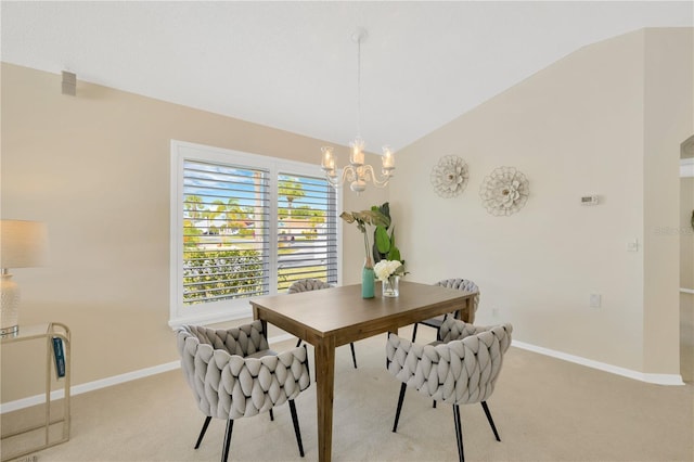 dining room with light colored carpet, vaulted ceiling, and an inviting chandelier