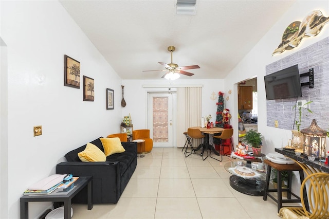 living room with ceiling fan, light tile patterned floors, and vaulted ceiling