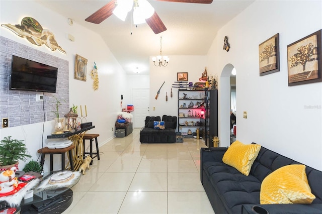 tiled living room with ceiling fan with notable chandelier and vaulted ceiling