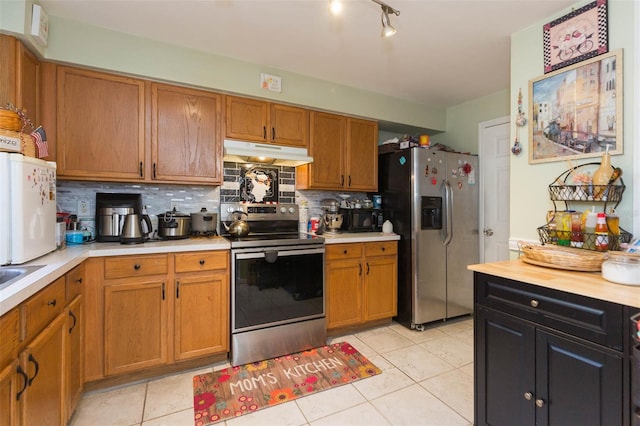 kitchen with decorative backsplash, light tile patterned floors, stainless steel appliances, and sink