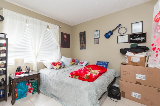 bedroom featuring light tile patterned floors, a textured ceiling, and multiple windows