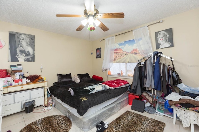 tiled bedroom with ceiling fan and a textured ceiling