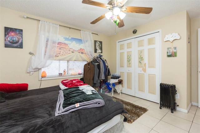 bedroom with ceiling fan, radiator heating unit, a textured ceiling, and a closet