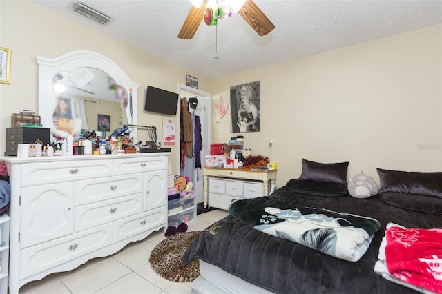 bedroom with light tile patterned floors, a textured ceiling, and ceiling fan