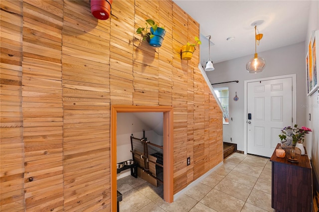 entrance foyer with wooden walls and light tile patterned floors