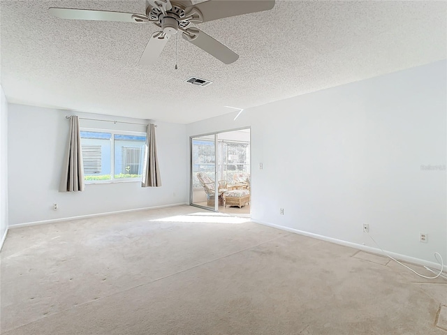 carpeted spare room featuring a textured ceiling and ceiling fan