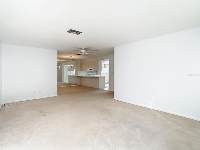 unfurnished living room featuring light carpet and a chandelier