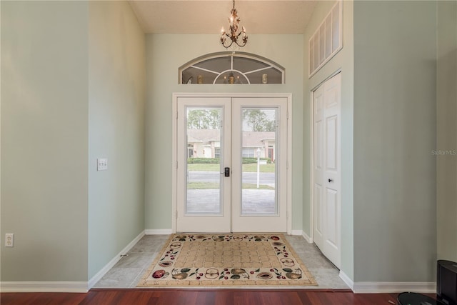 doorway to outside with french doors, hardwood / wood-style floors, a textured ceiling, and a notable chandelier