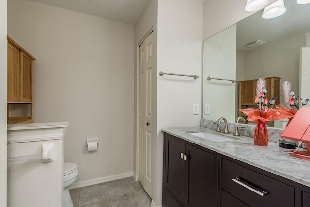 bathroom featuring tile patterned floors, vanity, and toilet